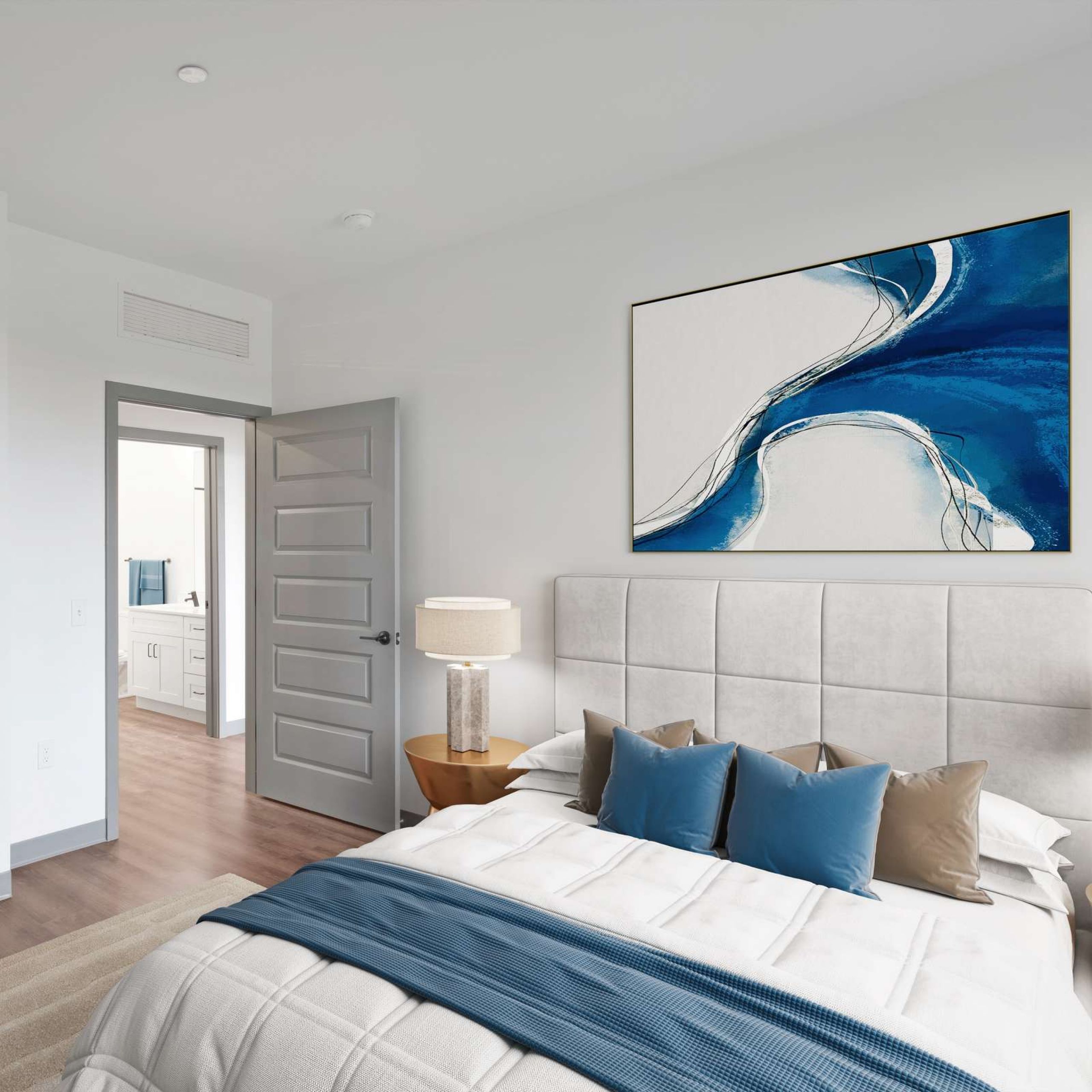 Modern bedroom with gray doors, a bed with blue accents, and abstract artwork above the headboard.